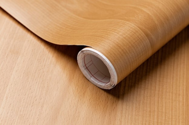 A roll of vinyl depicting natural wood.